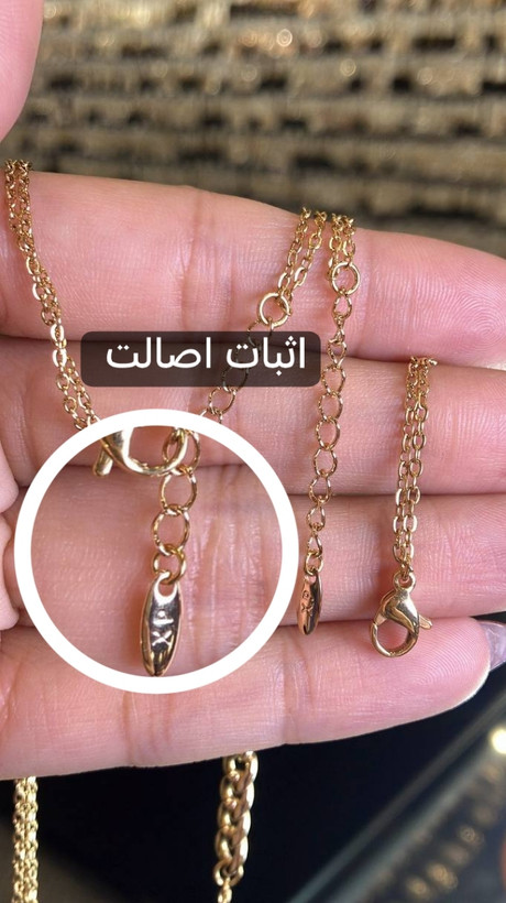 تصویر نمای نزدیک قفل طوطی سرویس ژوپینگ اورجینال مدل کارتیه، با نمایش قفل فلزی، حلقههای اتصال زنجیر دیپلمات ظریف و آبکاری طلایی، همراه با حک لیزری XP جهت اثبات اصالت محصول